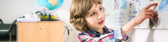Schulkind an der Grundschule Gau-Odernheim zeigt etwas an der Tafel